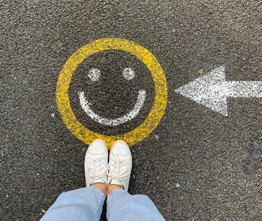 person in white shoes standing on gray concrete road