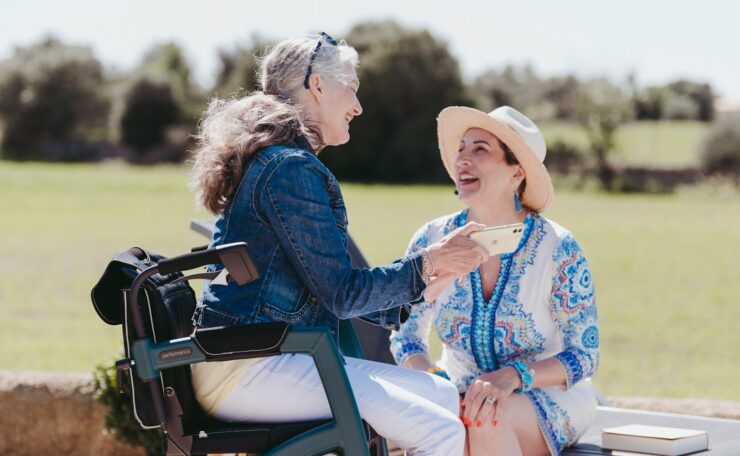 two women sitting on a bench talking to each other